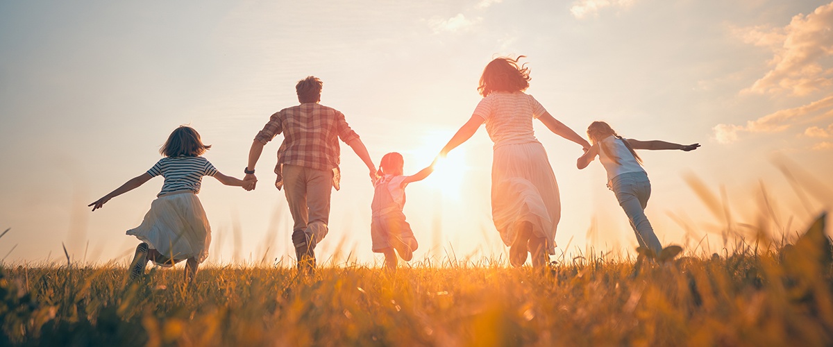 Happy healthy family running in a field